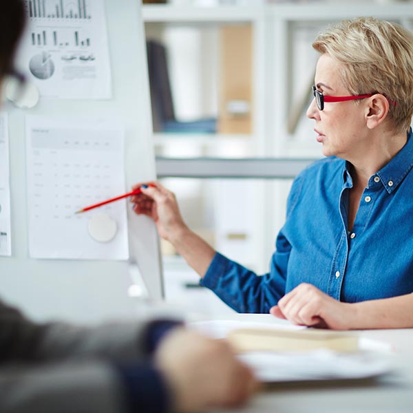 Una mujer señala un gráfico y explica